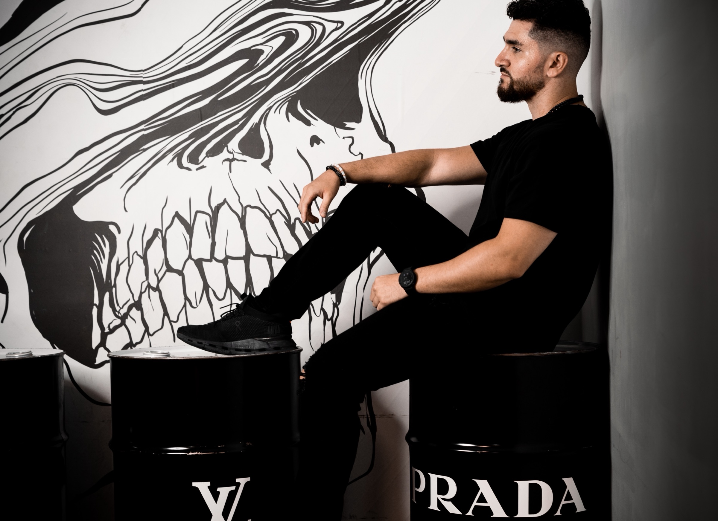 Andres Hernandez seated in front of an illustrated wall
